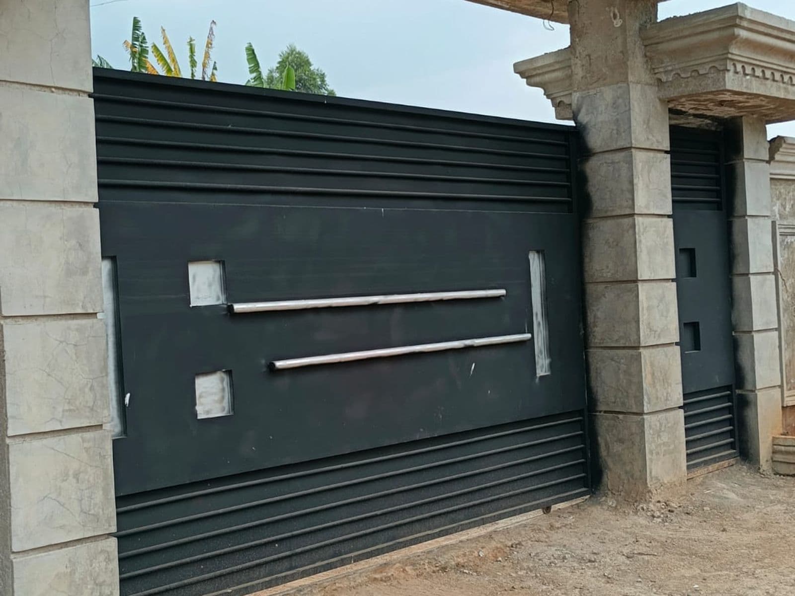Double-leaf steel swing gate with vertical bar detailing